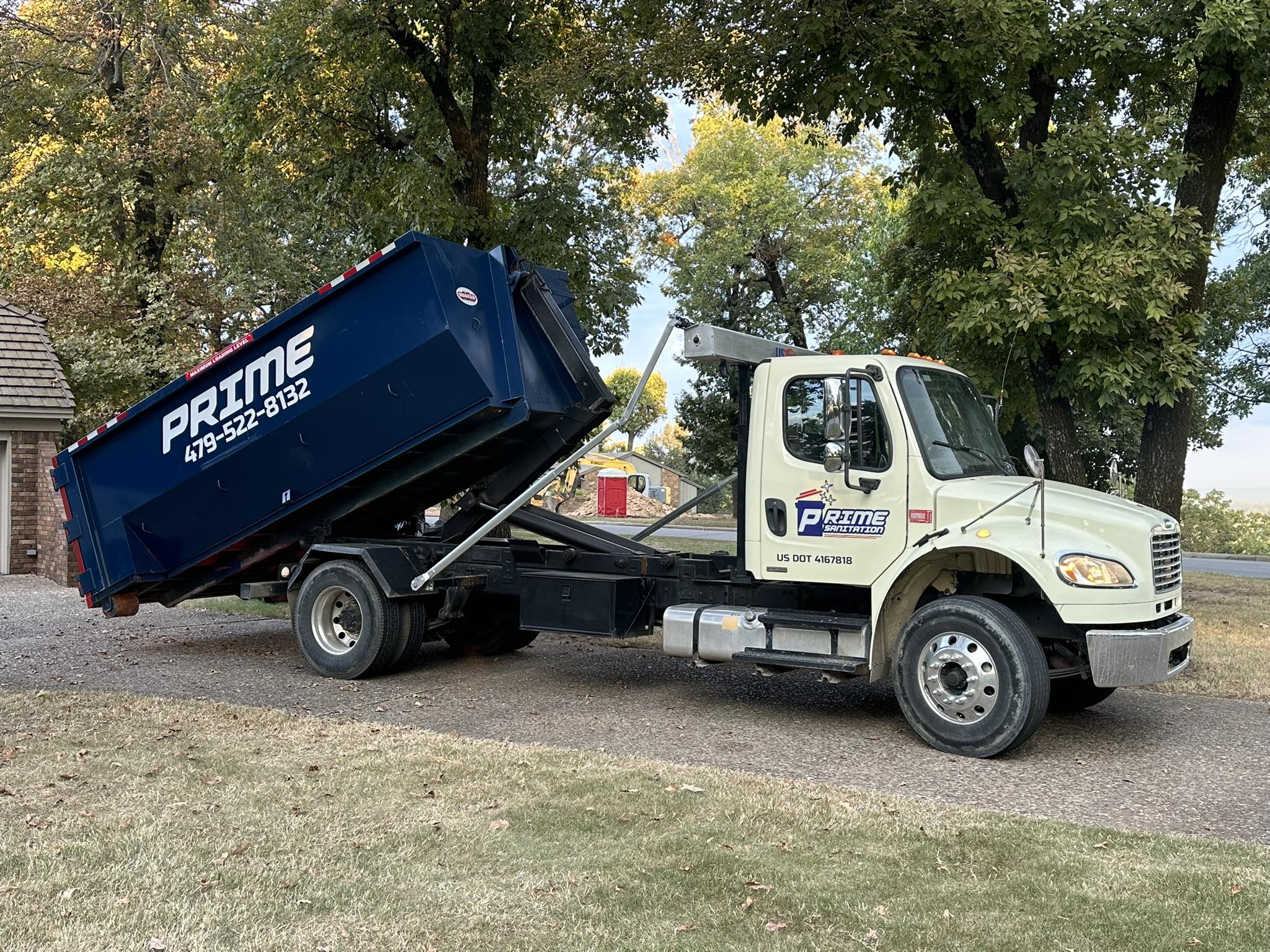Prime Dumpster Rentals roll-off dumpster being delivered to a home in Fort Smith AR
